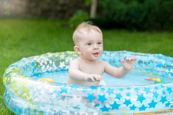 Ritratto di adorabile bambino che gioca in piscina in giardino — Foto Stock