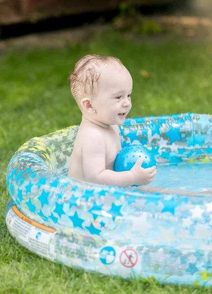 Menino alegre jogando na piscina inflável — Fotografia de Stock