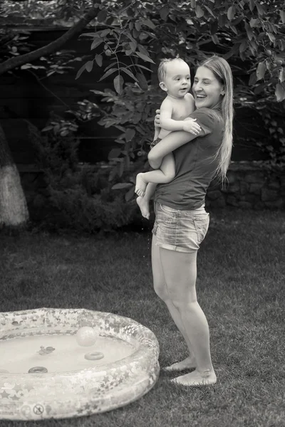 Imagen en blanco y negro de la madre abrazando a su bebé después de nadar —  Fotos de Stock