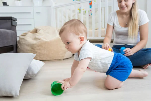 Bedårande 10 månader gammal baby krypa och ha kul på golvet vid — Stockfoto