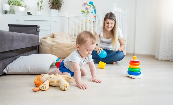 Lindo bebé de 10 meses jugando en el suelo con juguetes coloridos — Foto de Stock