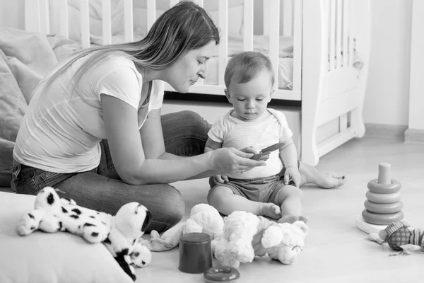 Image noir et blanc de la jeune mère jouant avec son bébé sur f — Photo