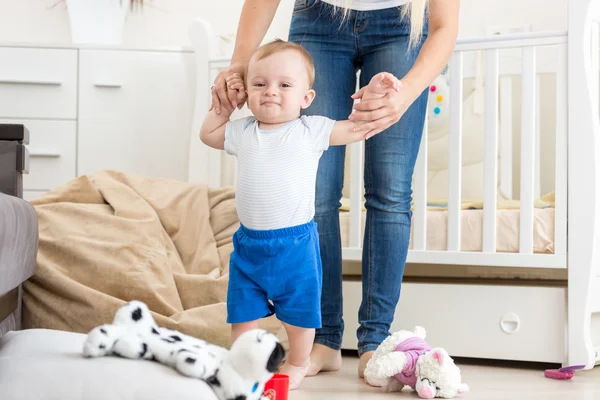 Söt baby att lära sig att gå med mamma hemma — Stockfoto