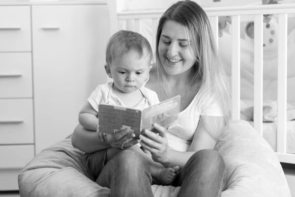 Retrato preto e branco de mãe alegre sentada com bebê em — Fotografia de Stock