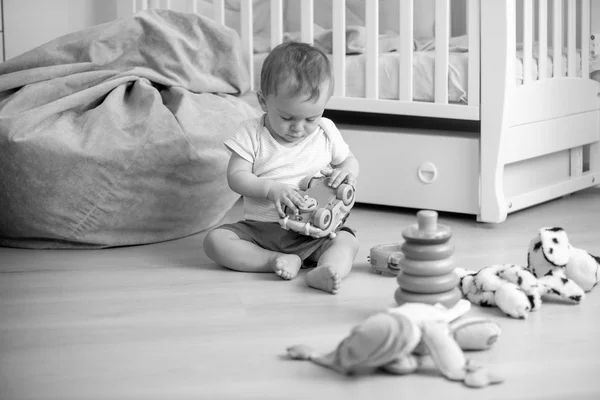 Imagen en blanco y negro del bebé jugando en el suelo con juguetes —  Fotos de Stock