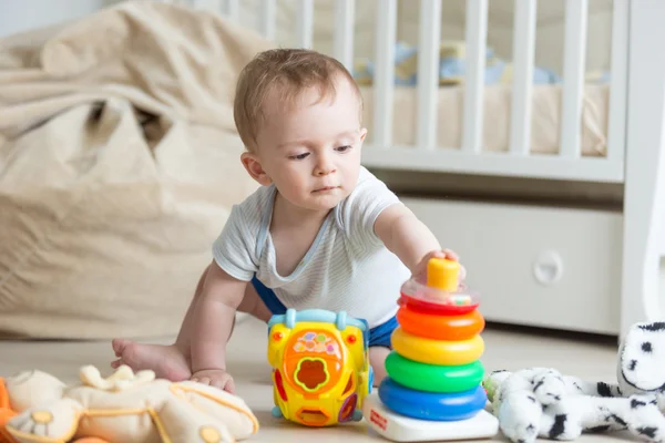 Porträtt av 10 månader gammal baby leker med färgglad leksak tower — Stockfoto