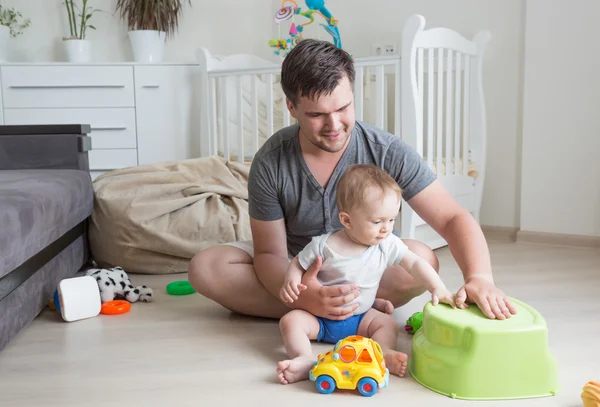 Веселый отец веселится со своим ребенком и играет на полу в — стоковое фото