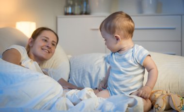 Geceleri yatakta oturuyor ve anne olarak seyir bebek çocuk