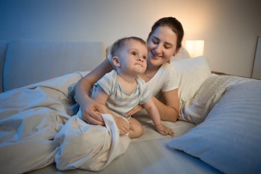 Şirin bebek çocuk ve annesi geç gece yatakta
