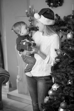 Santa şapka lı mutlu genç annenin siyah beyaz portresi ve 