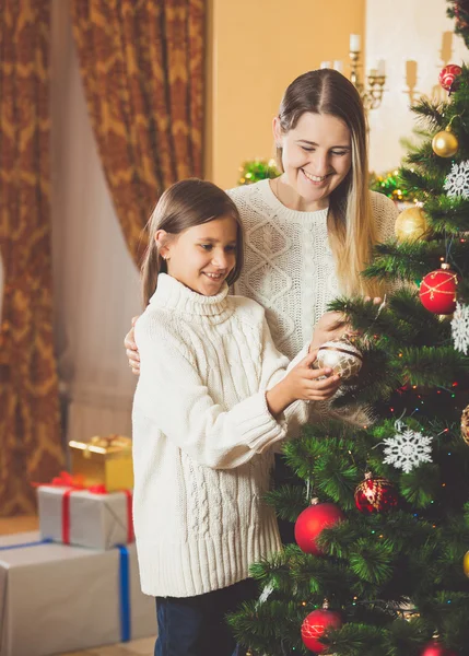 Tonårig flicka att hjälpa mor dekorera julgran — Stockfoto