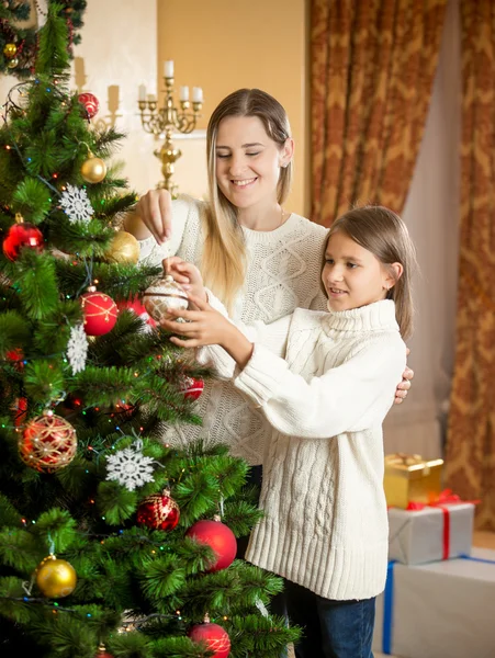 Vrolijke moeder met dochter decoreren kerstboom met col — Stockfoto