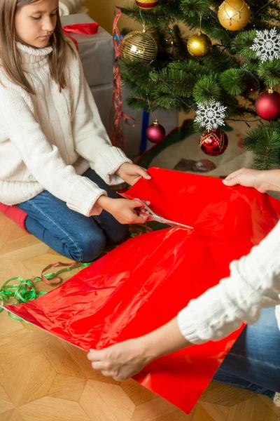 クリスマスのラッピングの赤い紙 p を切断の女の子のクローズ アップ イメージ — ストック写真