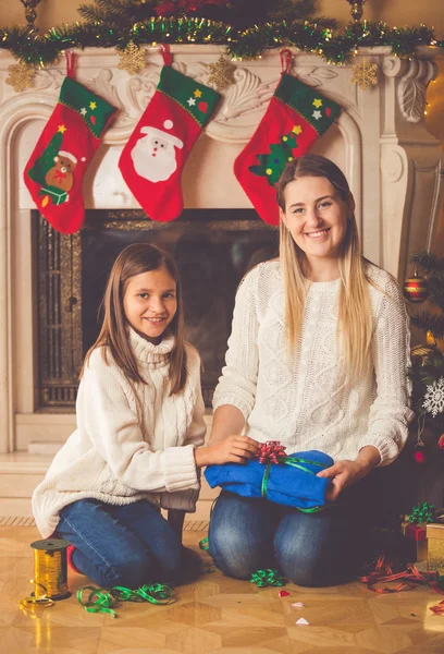 Getöntes Bild glücklicher Mutter und Tochter beim Packen von Weihnachtsgeschenken — Stockfoto