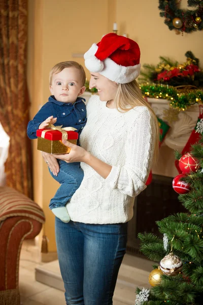 Wesoła młoda matka dając prezent swojemu dziecku syna na christma — Zdjęcie stockowe