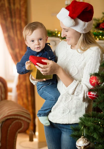Glückliche junge Mutter schenkt ihrem kleinen Jungen zu Weihnachten eine Geschenkbox — Stockfoto