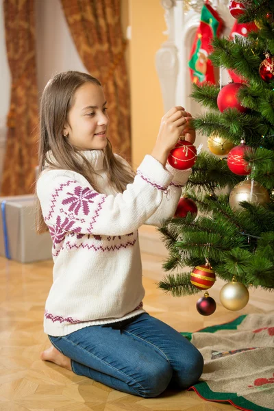 Menina alegre decorando árvore de Natal em casa — Fotografia de Stock