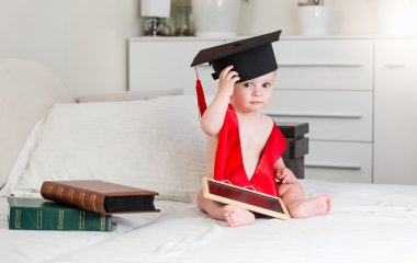 10 aylık bebek çocuk Mezuniyet giyen kitaplarla portresi