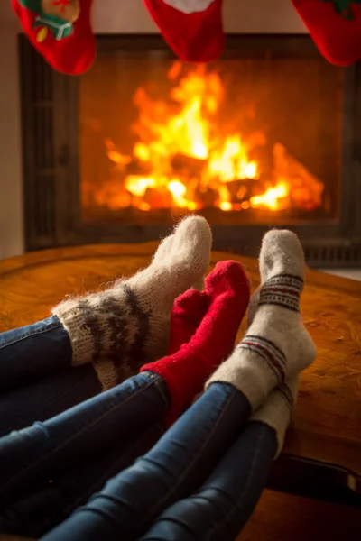 Famille portant des chaussettes en laine assis dans le chalet en brûlant firepla — Photo