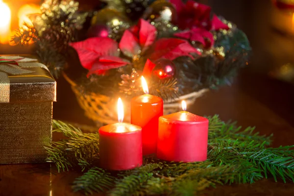 Декоративный венок с горящими красными свечами на столе на живой ро — стоковое фото