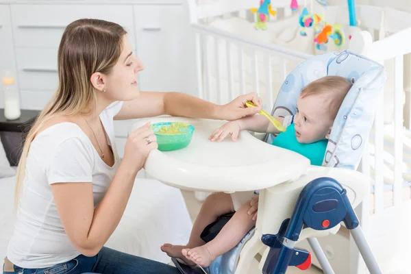 Портрет красивой женщины кормить 9 месяцев мальчик сидит — стоковое фото