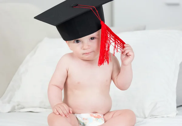 Retrato de adorable bebé niño en gorra de graduación negro con t rojo — Foto de Stock