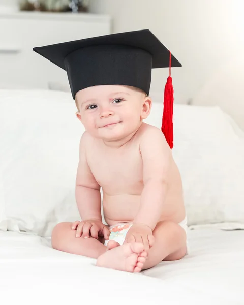 Ritratto tonico del bambino sorridente in cappello di laurea guardando dentro — Foto Stock