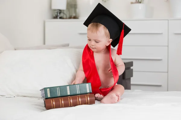 Retrato divertido de 10 meses bebé en gorra de graduación mirando bi —  Fotos de Stock