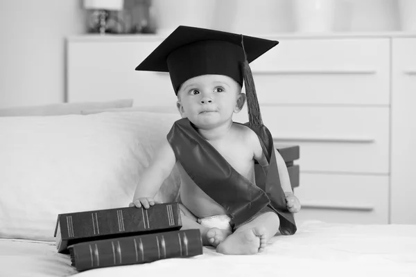 Retrato en blanco y negro del niño en la graduación sentado con — Foto de Stock