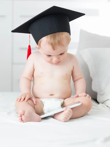 10 månader gammal baby i blöjor bär examen cap och med hjälp av t — Stockfoto