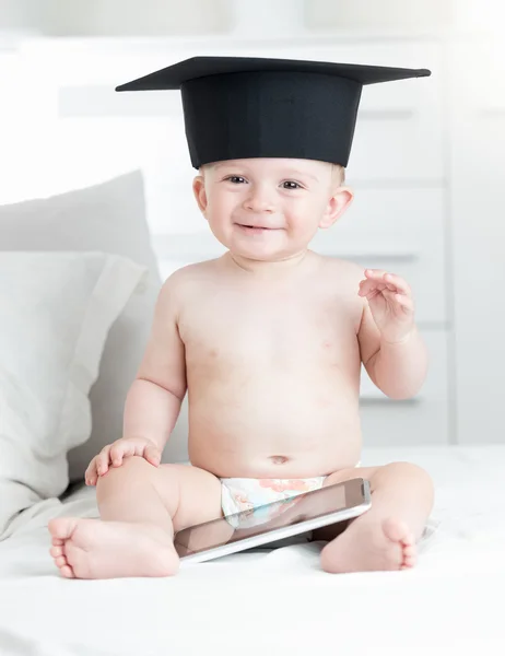 아기 소파 w에 앉아 졸업 모자에 미소의 초상화 — 스톡 사진