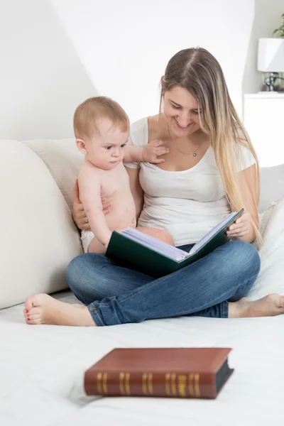 Hermosa madre mostrando imágenes en libro viejo a su 9 meses de edad —  Fotos de Stock