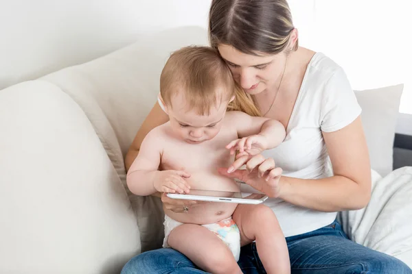 Geconcentreerd jongetje en jonge moeder op tablet scherm aan te raken — Stockfoto