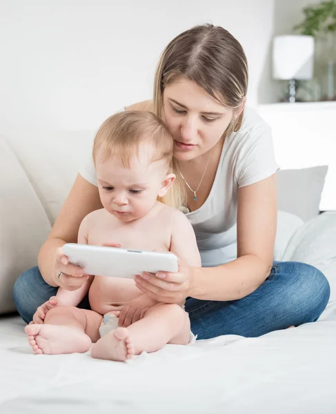 Schattig baby in luiers met behulp van tablet Pc met zijn moeder — Stockfoto