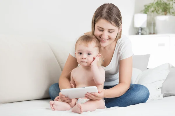 Jeune mère et bébé garçon en couches utilisant la tablette pc — Photo