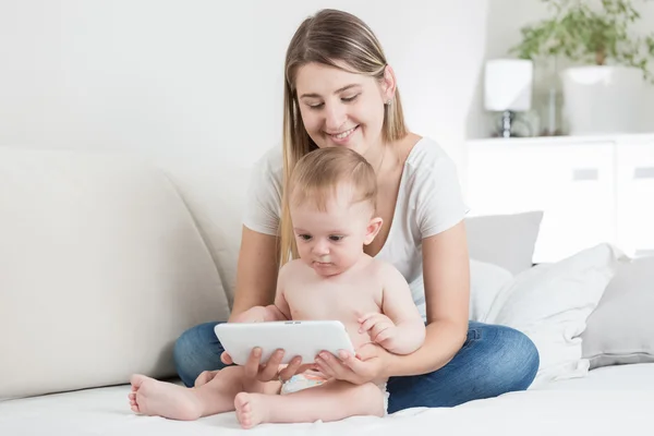 Gladlynt mor sittande på soffan med hennes pojke och surfar jag — Stockfoto