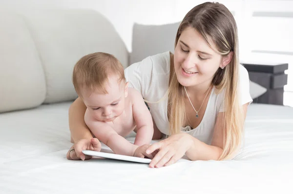 Güzel genç anne bebek oğlu compu tablet kullanmayı öğretmek — Stok fotoğraf
