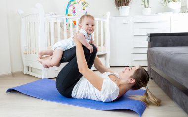 Güzel anne bebek oğlu ile Yoga uygulamak