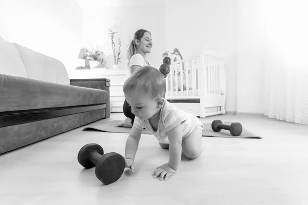 Imagen en blanco y negro del niño jugando con pesas mientras m — Foto de Stock