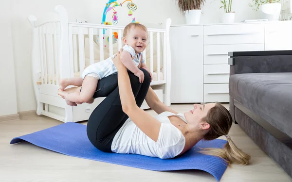 Bella madre che pratica yoga con il suo bambino — Foto Stock