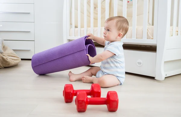 Adorable niño jugando con pesas y colchoneta de fitness en vivo ro — Foto de Stock
