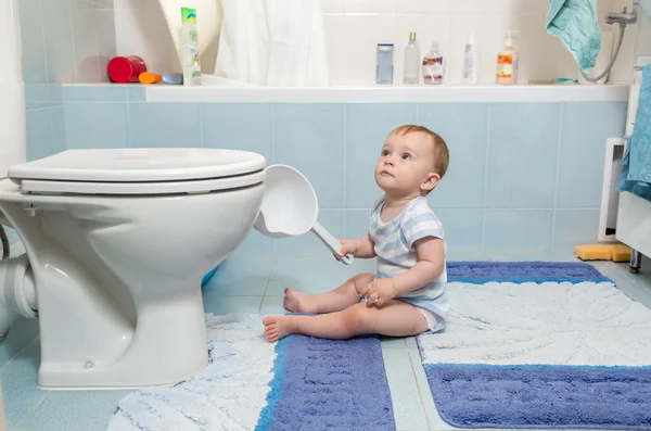 Menino sentado no chão no banheiro — Fotografia de Stock