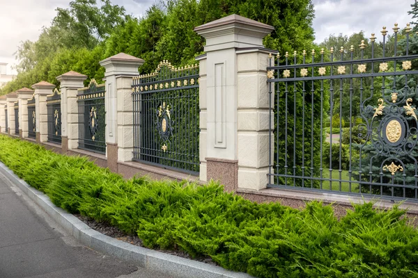 Kute ogrodzenia malowane złotem przy wejściu do luksusowych willi — Zdjęcie stockowe