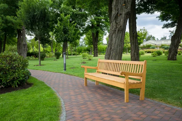 Dřevěná lavice na cesty v parku — Stock fotografie