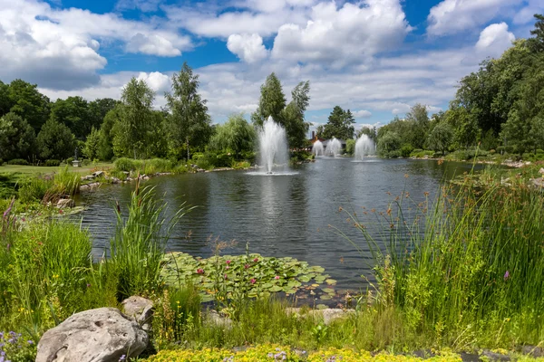 Пейзаж ставка з фонтанами в парку в сонячний день — стокове фото