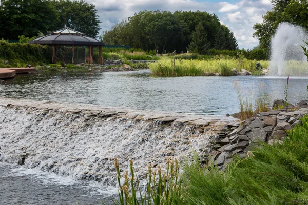 Beautiful view on cascade of water flowing from pond in park — Stock Photo, Image