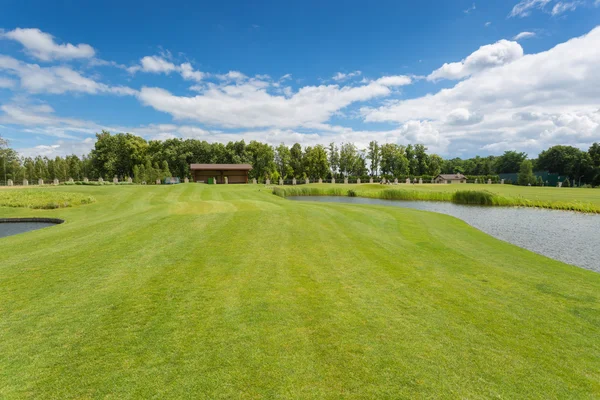 Hermoso campo de golf con hierba perfecta y obstáculos de agua en —  Fotos de Stock