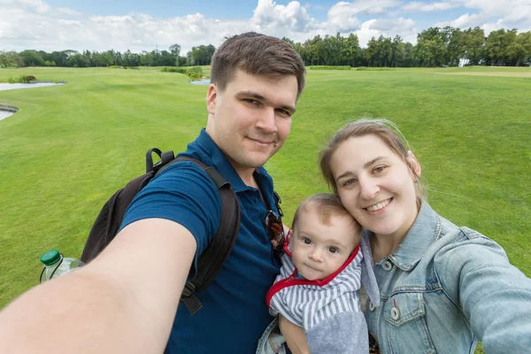 Portrait of beautiful happy family with baby making selfie at pa — Stock Photo, Image