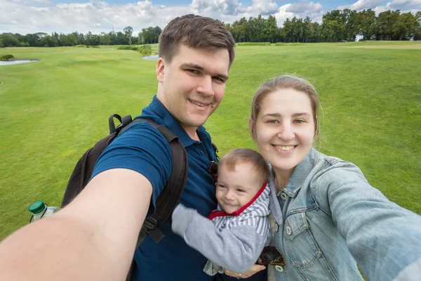 Şirin Bebek Park'ta rahatlatıcı ile mutlu aile Selfie görüntü — Stok fotoğraf