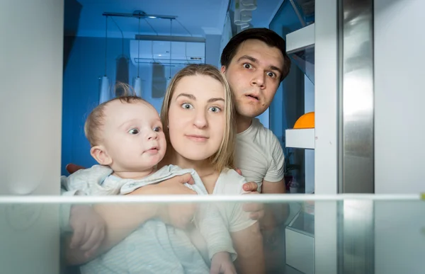Rodina v pyžamu uvnitř chladničky něco hledá — Stock fotografie
